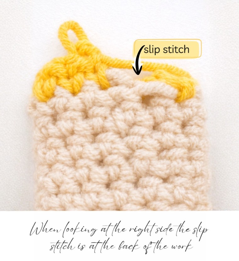 Close-up of a crochet swatch showing a yellow slip stitch at the back of the work, with an arrow pointing to the slip stitch on the right side.